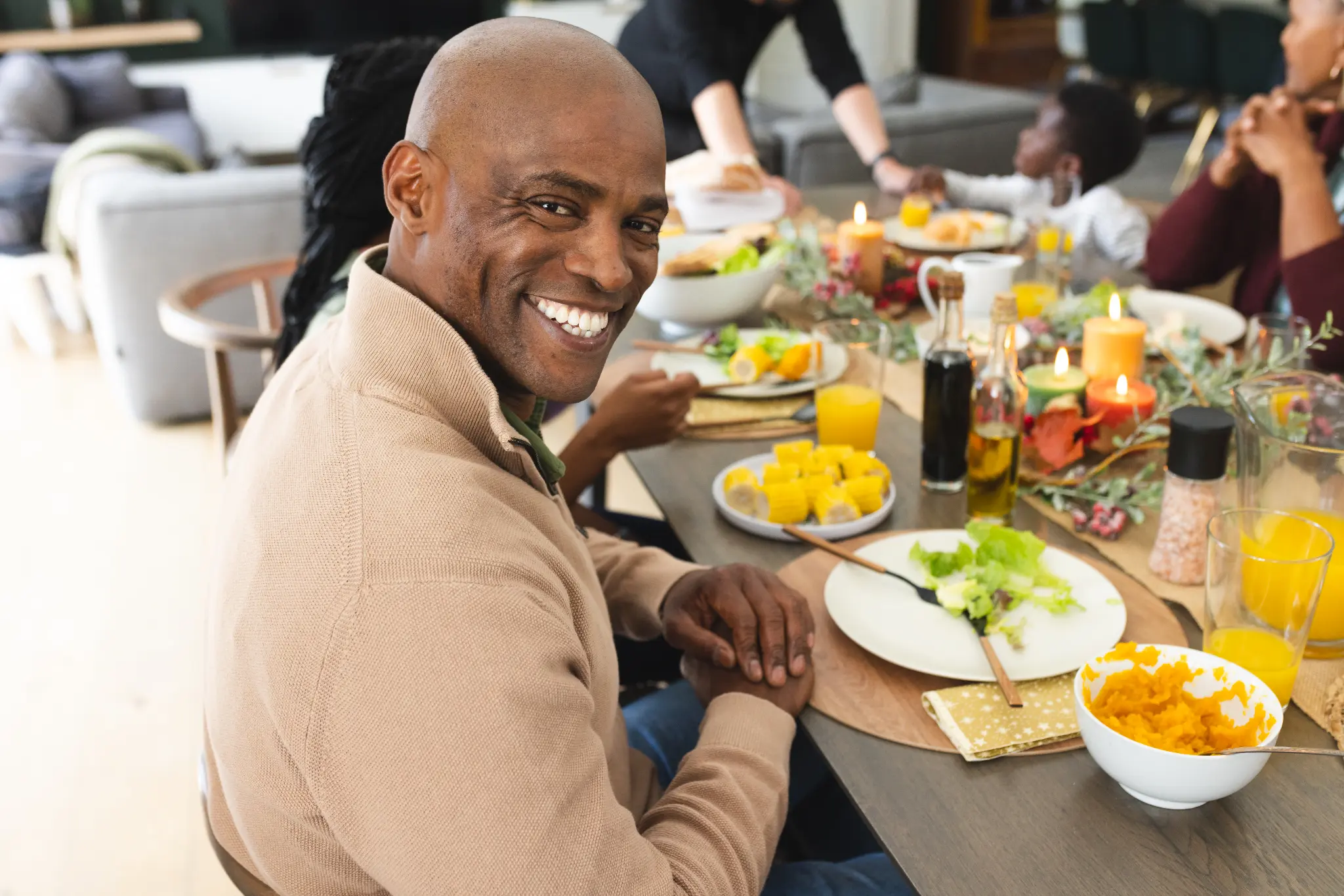 Smiling man enjoying a family meal after dental implant treatment
